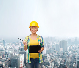 Image showing smiling woman in helmet with clipboard