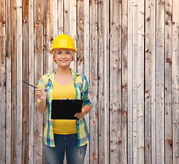 Image showing smiling woman in helmet with clipboard