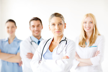 Image showing serious female doctor in front of medical group