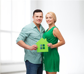 Image showing smiling couple holding green paper house