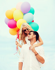 Image showing couple with colorful balloons at seaside