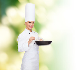 Image showing smiling female chef with pan and spoon