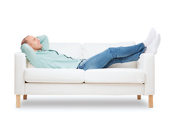 Image showing smiling man lying on sofa