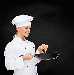 Image showing smiling female chef with pan and spoon