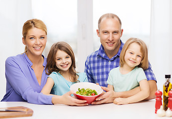 Image showing happy family with two kids with salad at home