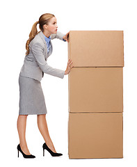 Image showing busy businesswoman pushing tower of cardboards
