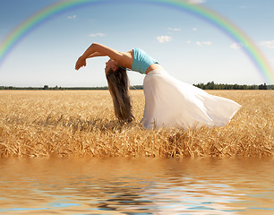 Image showing stretching woman with rainbow and water