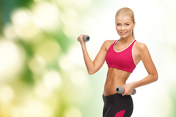 Image showing young sporty woman with light dumbbells