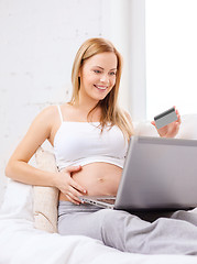 Image showing smiling pregnant woman with laptop computer