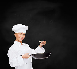 Image showing smiling female chef with pan and spoon