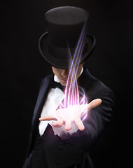 Image showing magician holding something on palm of his hand