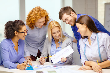 Image showing smiling creative team looking at sketch