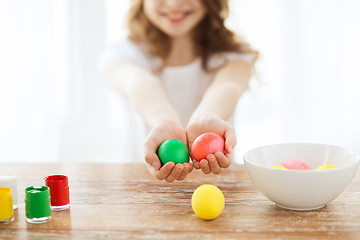 Image showing close up of girl holding colored eggs