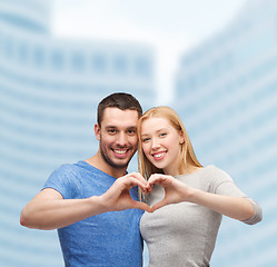 Image showing smiling couple showing heart with hands