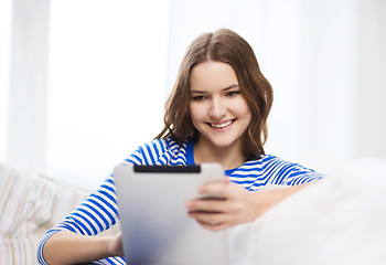Image showing smiling teenage girl with tablet pc at home
