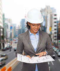 Image showing businesswoman in white helmet with blueprint