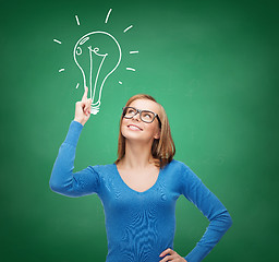 Image showing smiling woman pointing her finger up