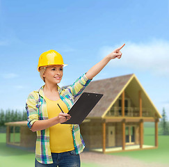 Image showing smiling woman in helmet with clipboard