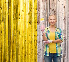 Image showing smiling woman with paintbrush