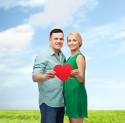 Image showing smiling couple holding big red heart