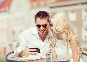 Image showing couple looking at smartphone in cafe