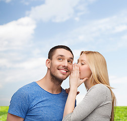 Image showing smiling girlfriend telling boyfriend secret