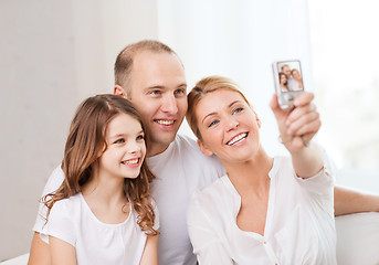 Image showing happy family with little girl making self portrait