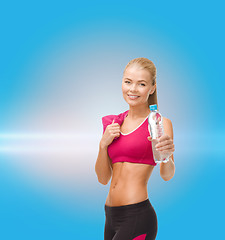 Image showing sporty woman with bottle of water and towel