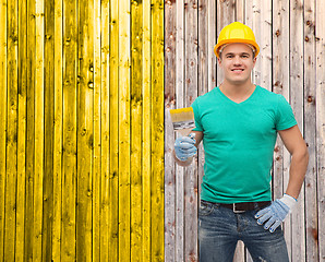 Image showing smiling manual worker in helmet with paintbrush