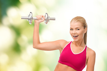 Image showing smiling woman with heavy steel dumbbell