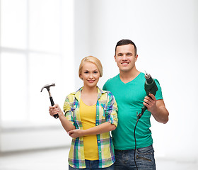 Image showing smiling couple with hammer and drill