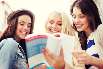 Image showing beautiful girls looking into tourist book in city