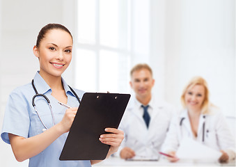 Image showing smiling female doctor or nurse with stethoscope