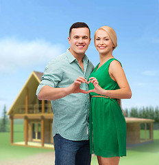 Image showing smiling couple showing heart with hands