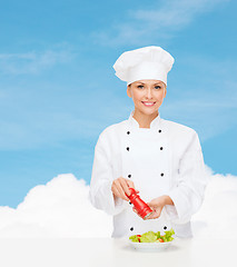 Image showing smiling female chef with preparing salad