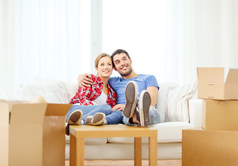 Image showing smiling couple relaxing on sofa in new home