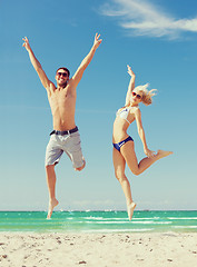 Image showing couple jumping on the beach