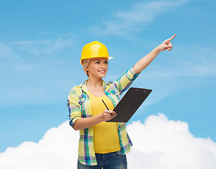 Image showing smiling woman in helmet with clipboard