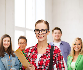 Image showing female student in eyeglasses with bag and folders