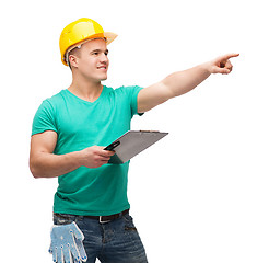 Image showing smiling man in helmet with clipboard