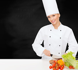 Image showing smiling female chef chopping vagetables