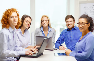 Image showing smiling team with laptop and table pc computers