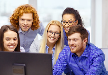 Image showing smiling business team looking at computer monitor