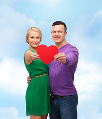 Image showing smiling couple holding big red heart