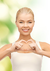 Image showing smiling woman showing heart shape gesture