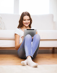 Image showing smiling teenage girl with tablet pc at home