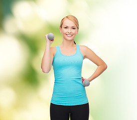 Image showing young sporty woman with light dumbbells