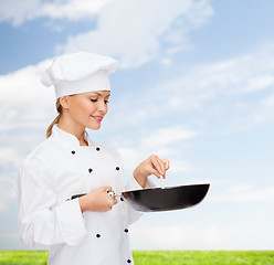 Image showing smiling female chef with pan and spoon