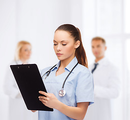 Image showing serious female doctor or nurse with stethoscope