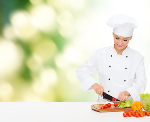 Image showing smiling female chef chopping vagetables